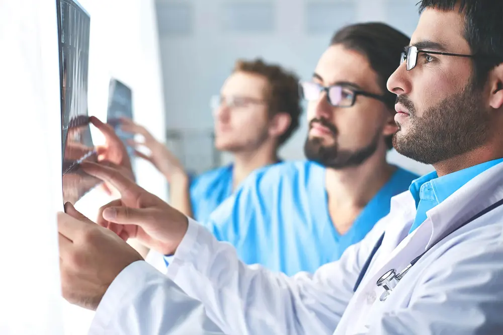 Tres médicos revisan una radiografía