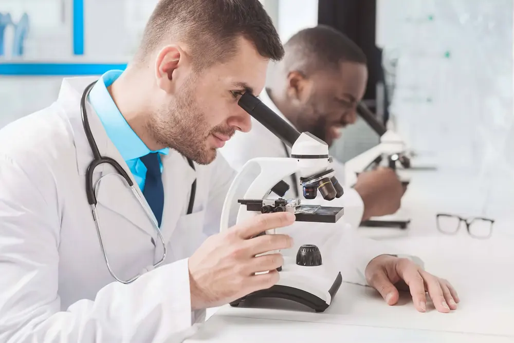 Dos médicos trabajan con un microscopio en un laboratorio